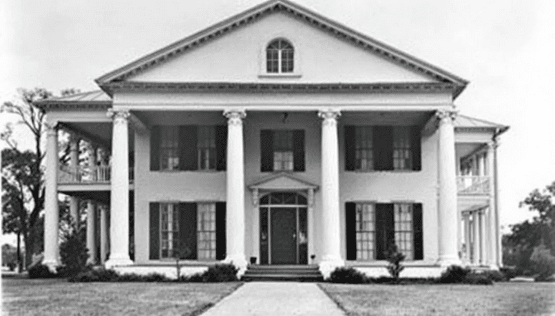 The image features a historical black and white photograph of a classic antebellum plantation house, showcasing its tall columns, wraparound porches, and symmetrical design, typical of southern style house plans from the Civil War era. The plantation home stands as a testament to the architectural elegance and grace of the time, surrounded by vast outdoor living spaces.