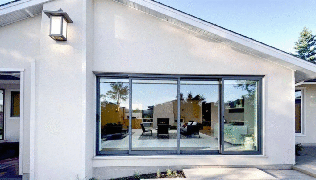 Exterior Of a White Ranch - Ranch Style Homes USA The image depicts the exterior of a ranch style home featuring horizontal sliding windows and large sliding glass doors, which enhance the indoor-outdoor living experience by allowing natural light to flow seamlessly into the dining room and living areas. The sleek design and clean lines of the windows complement the home's architectural style, contributing to its overall curb appeal.