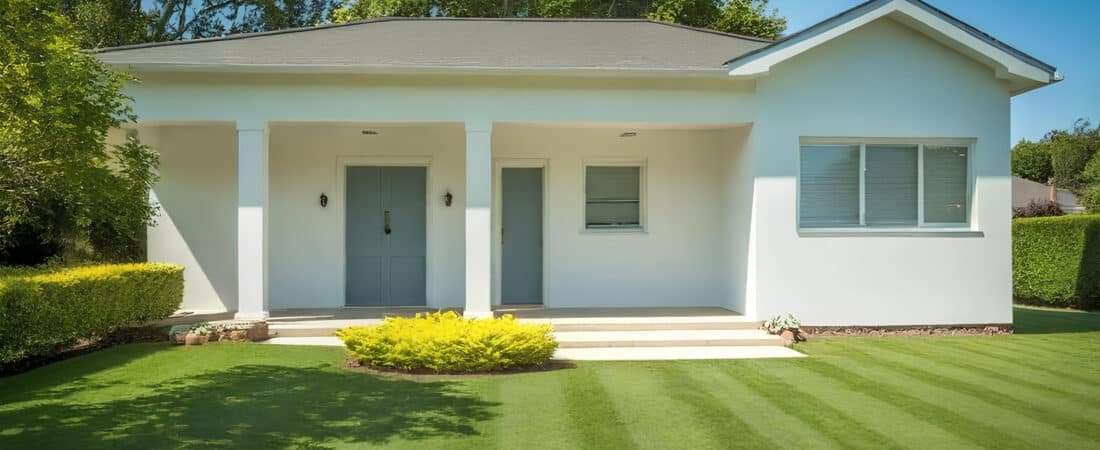 Ranch vs 2 Story Comparison - Ranch Style Homes USA Photograph of a charming, well-maintained single-story house with a neatly manicured lawn and vibrant landscaping under a clear blue sky, evoking comfort and aspiration.