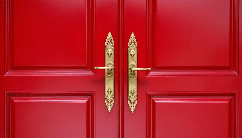 Red Door - Ranch Style Homes USA The image showcases a ranch style house featuring a striking new front door, designed with double doors that enhance the home's curb appeal. The entry door is painted in a bold color, surrounded by unique hardware and decorative trim, creating a welcoming entrance that adds visual interest to the home's exterior.