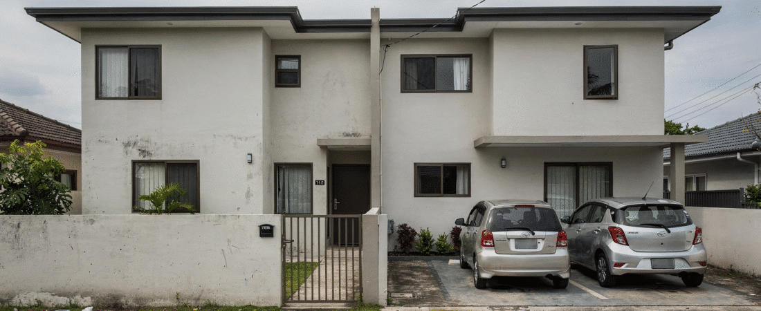 Two-story house with a gray and white exterior, two parked cars in front.