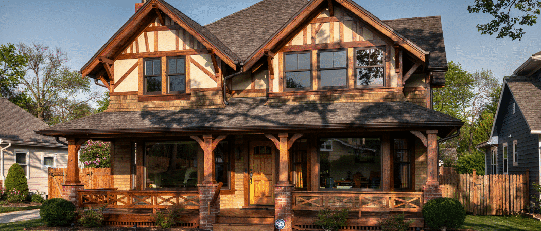 A large two-story house with brown wood details, front porch, and large windows.